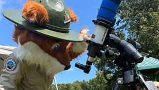 帕克·雷德福克斯通过望远镜观察